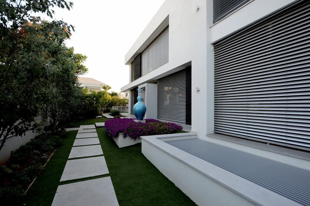 חצר של בית פרטי עם דשא וריצוף לבן