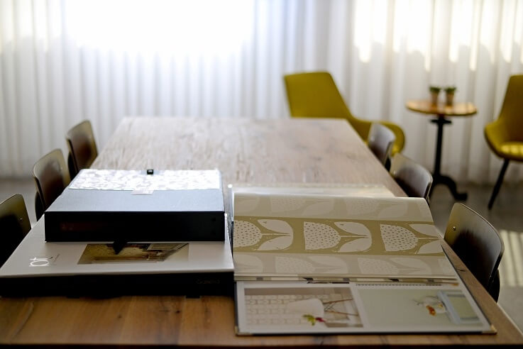 שולחן-ועליו-קטלוג-וילונות-של-חברת-דומוס